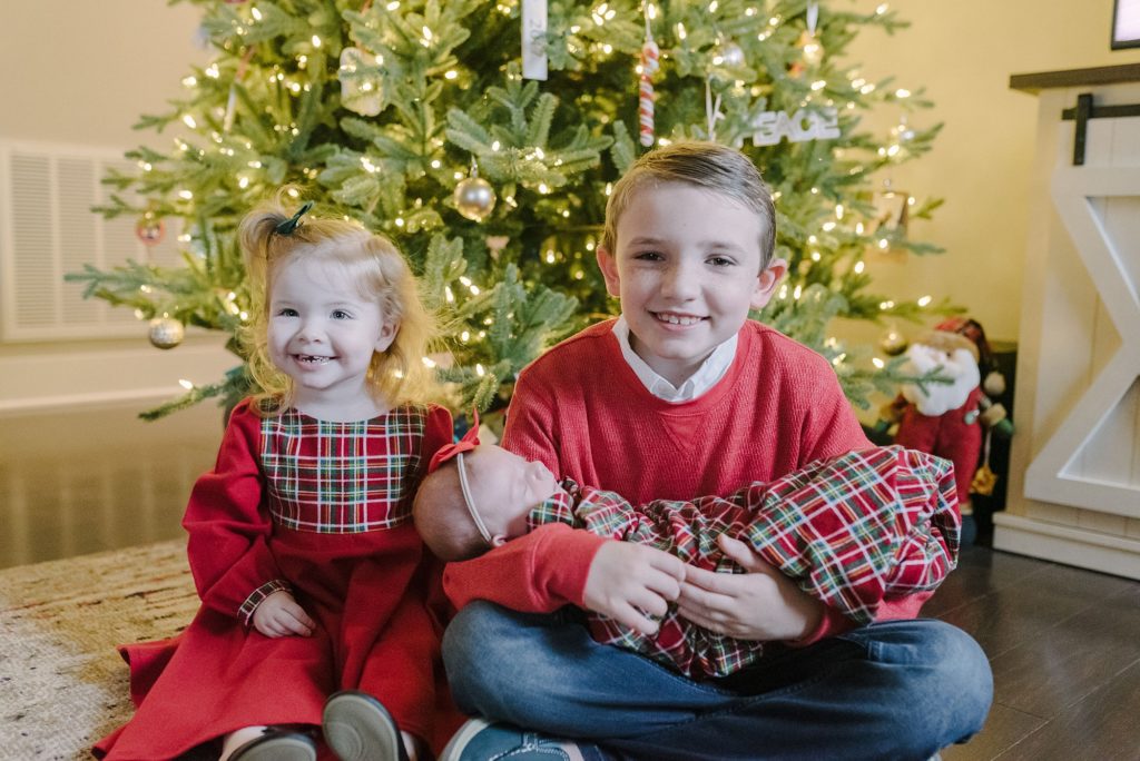 siblings posing for christmas photos by Nashville family. photographer Dolly DeLong Photography