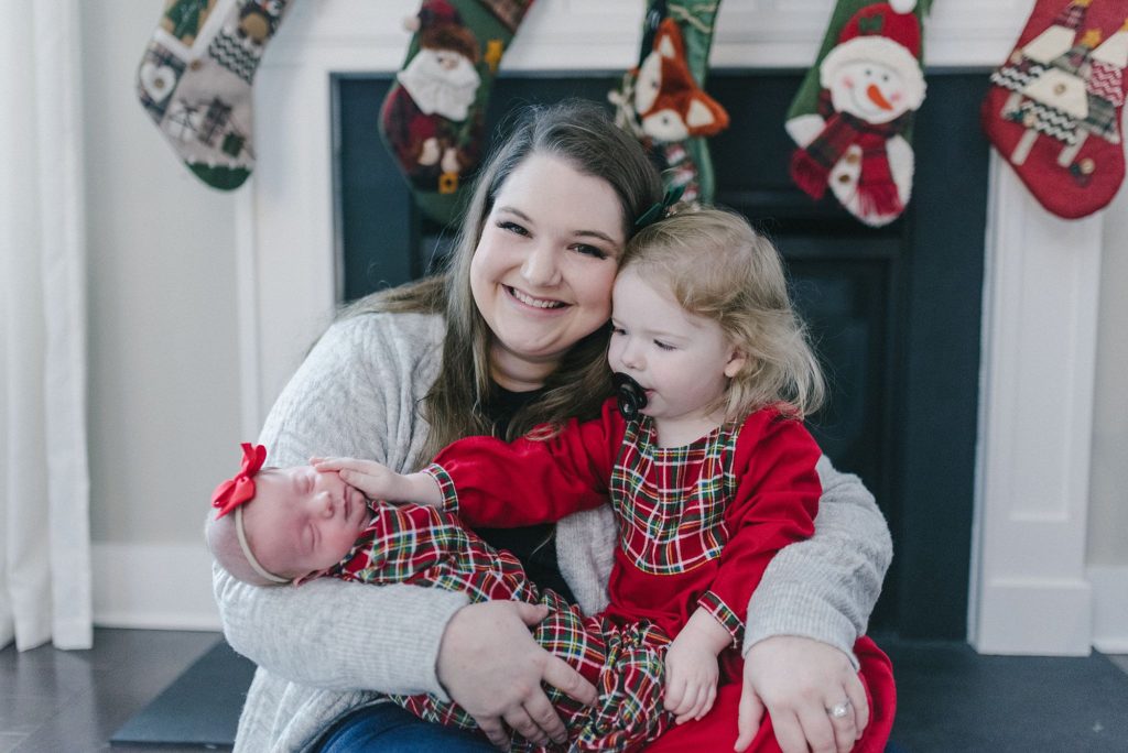 a mom holds her two daughters in her arms for christmas photos by Nashville family photographer Dolly DeLong Photography