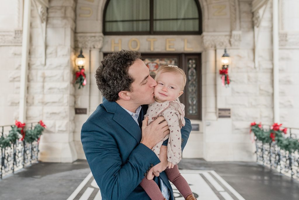 dad kisses one year old during first birthday portraits