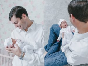dad holds baby girl in lap during newborn session in Nashville nursery