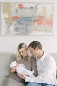 lifestyle newborn session with parents on couch in Nashville