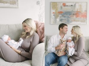 parents snuggle with newborn baby girl and dog on couch