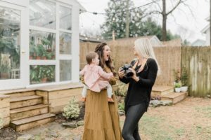 photographer shows mother photo on camera during East Nash Greenhouse family photos