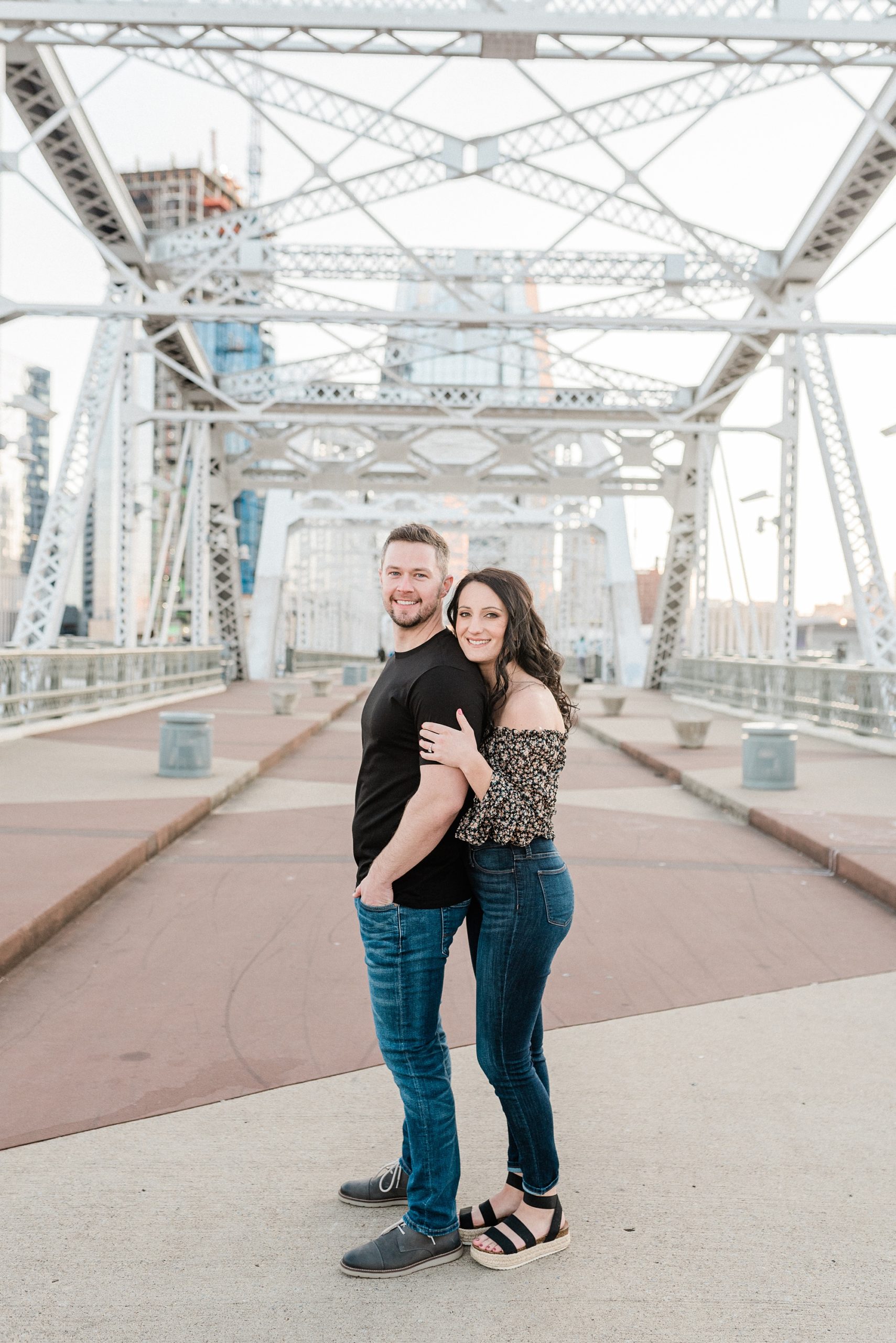 couple poses on the pedestrian bridge in Nashville TN