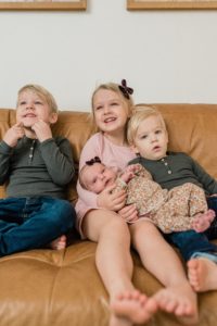 three siblings hold new sister during Franklin TN Newborn Portraits at Home