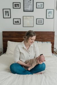 mom looks down at baby girl during Franklin TN newborn portraits at home