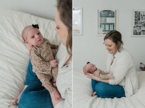 mom holds baby girl at home during newborn photos on bed