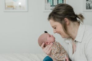 mom nuzzles baby girl during Franklin TN newborn portraits at home