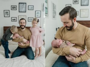 dad poses with new baby girl and toddlers on bed