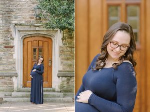 expecting mother holds belly posing in front of wooden door at Vanderbilt University