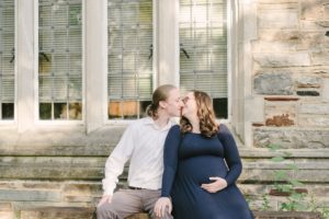 husband and wife kiss on stone bench at Vanderbilt University