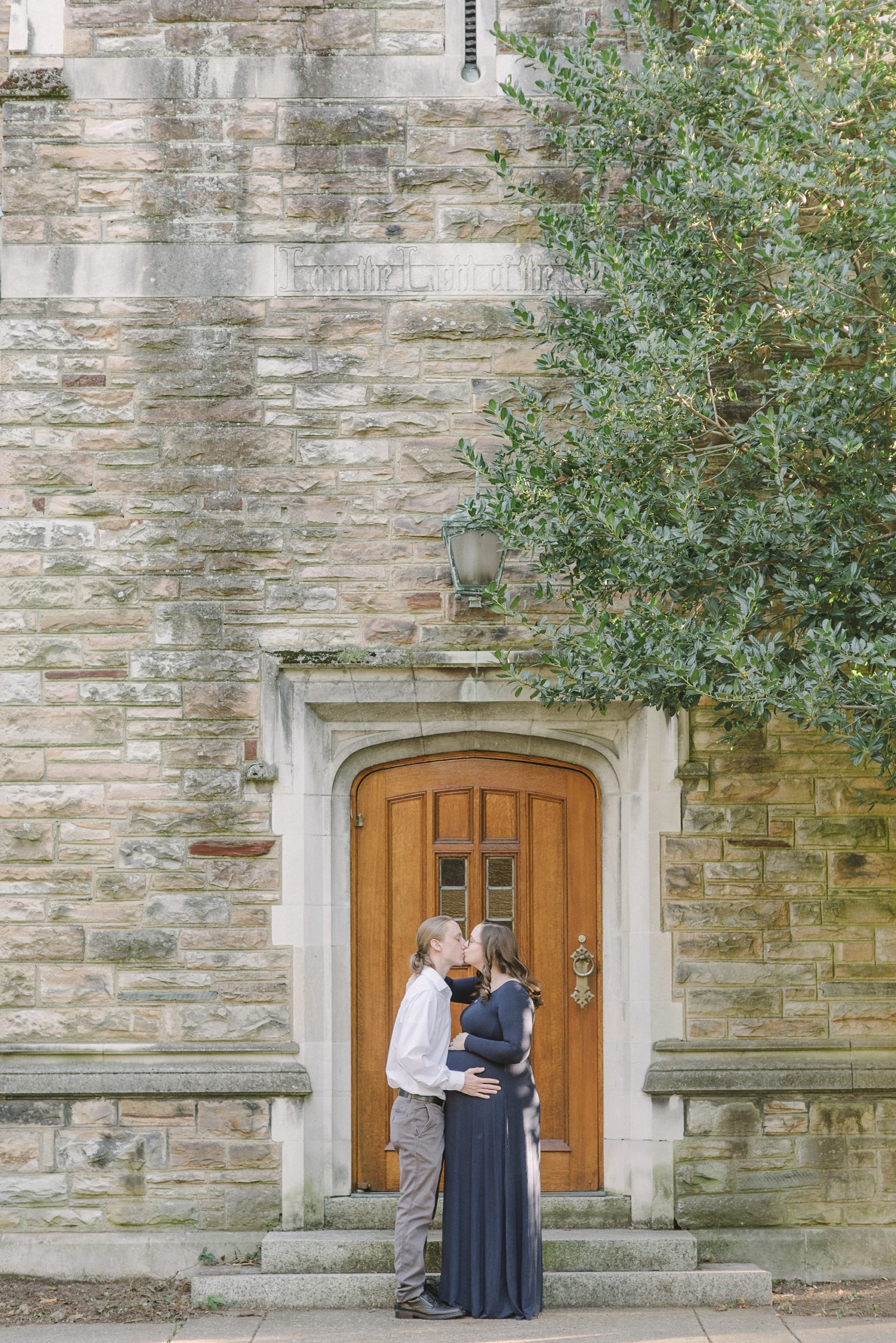 married couple kisses by wooden door at Vanderbilt University