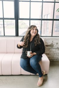 woman laughs on pink couch at Collective615