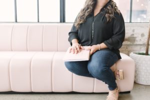 woman sits on pink couch during TN branding photos