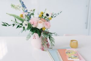 vase of flowers and pastel notebooks at Collective615