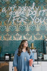 female business owner poses in front of coffee bar at Collective615