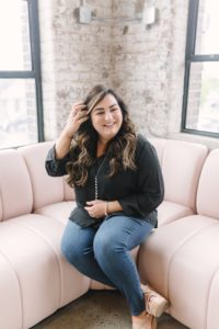 woman sits on pink couch during branding portraits in Nashville TN