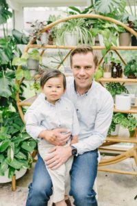 dad and son sit together during East Nashville Greenhouse mini sessions
