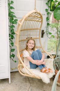 10 year old sits in curved chair during East Nashville Greenhouse mini sessions