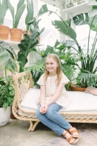 young girl sits on bench during East Nashville Greenhouse mini session