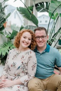 married couple sits by fern plant in East Nashville Greenhouse