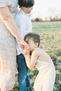 son kisses mom's hand during Murfreesboro Family Portraits with Film Photographer