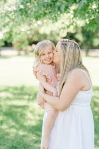 mom kisses toddler's cheek during posing Nashville maternity portraits