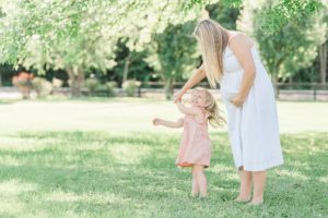 mom plays with toddler during Nashville maternity portraits