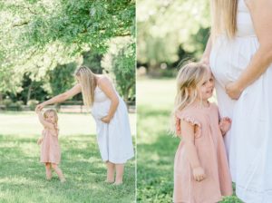 mom in white dress dances with toddler in pink dress