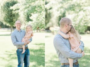dad holds daughter during spring family photos in backyard
