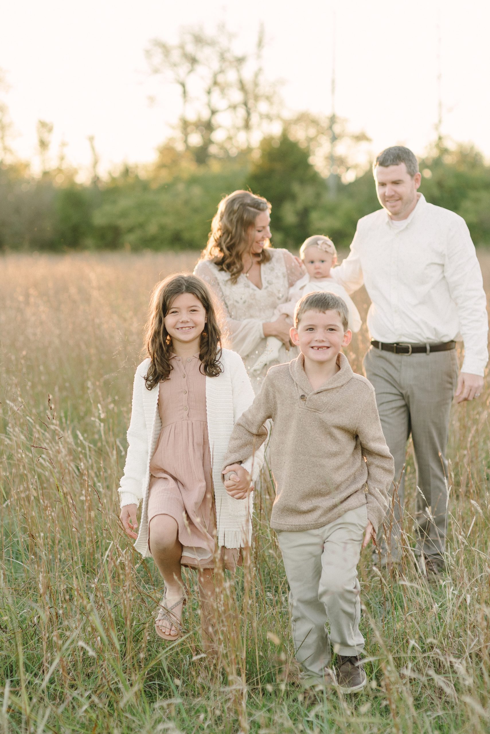 family walks together in field during Nashville family photos