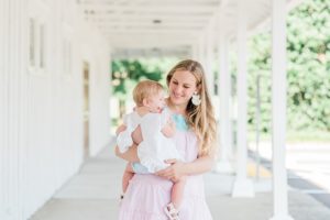 mom holds daughter during family photos on front porch