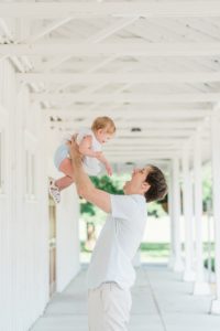 dad lifts toddler with cochlear implant during Nashville first birthday portraits
