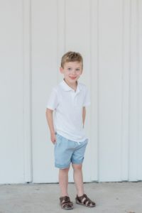 son stands by white wall at Nashville home