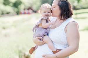 mom kisses toddler during Lavender Field Mini Sessions at Menkveld Farms