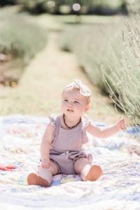 toddler sits in field of lavender during minis with Nashville family photographer