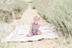 baby sits on heirloom quilt during Lavender Field Mini Sessions