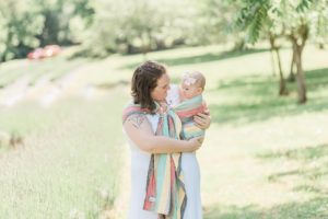 mom holds baby in sling during family mini session