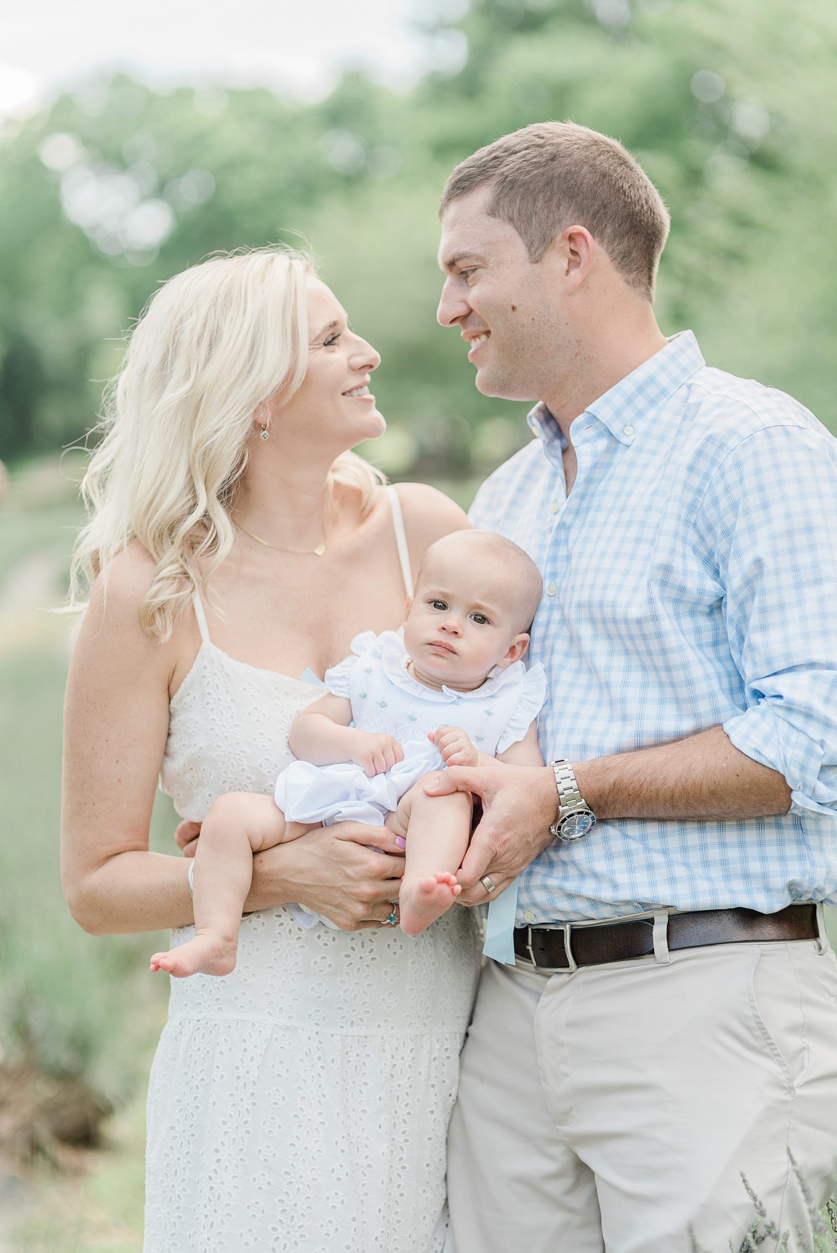 parents look at each other holding daughter during Nashville TN family photos