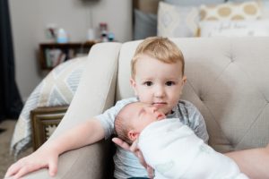 toddler holds baby brother during Nashville lifestyle newborn session