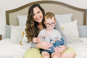 mom and son sit on bed during family photos