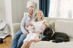 parents pose with son, daughter, and dog on couch at home