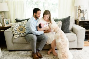 parents sit on couch with newborn and dog during Nashville newborn session at home