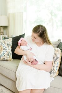 mom looks at daughter during newborn photos at home