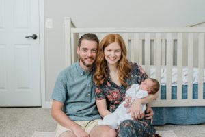 parents sit by crib during Franklin TN newborn session at home