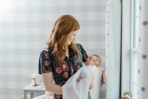 mom rocks daughter during newborn photos