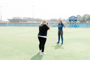 portrait photographer works on softball field