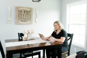 woman works at kitchen table during branding photos