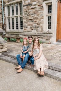 parents sit on steps with children during family photos in Nashville