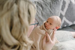 mom looks at baby boy during newborn photos